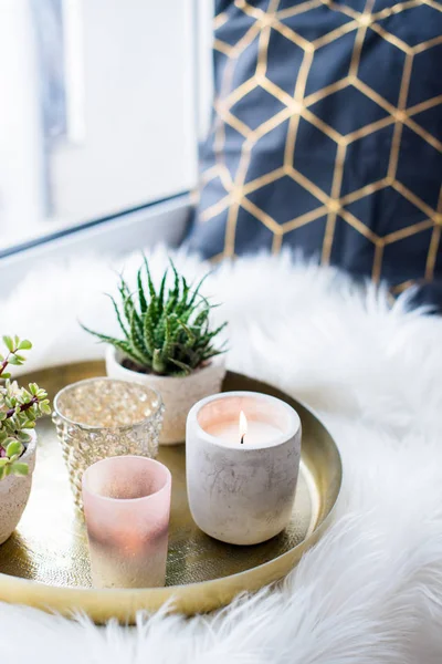 Acogedora decoración casera real, velas ardientes en bandeja de oro con almohada en piel sintética blanca en alféizar de ventana —  Fotos de Stock