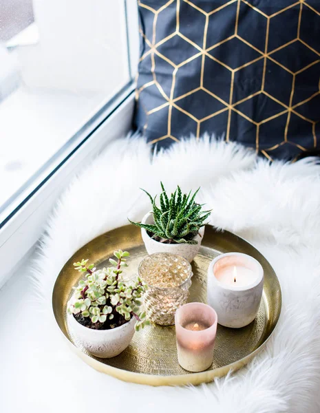 Confortable décoration de maison, bougies allumées sur plateau doré avec oreiller sur fausse fourrure blanche sur le rebord de la fenêtre — Photo