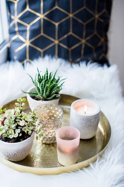 Acogedora decoración casera real, velas ardientes en bandeja de oro con almohada en piel sintética blanca en alféizar de ventana —  Fotos de Stock
