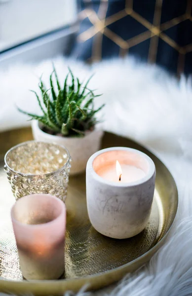 Aconchegante decoração de casa real, queimando velas na bandeja dourada com travesseiro na pele de falso branco no peitoril da janela — Fotografia de Stock