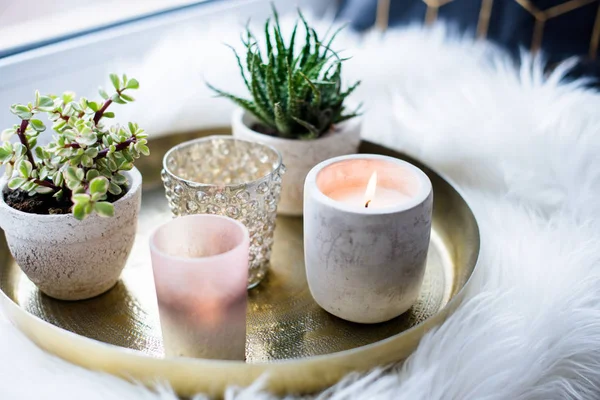 Acogedora decoración casera real, velas ardientes en bandeja de oro con almohada en piel sintética blanca en alféizar de ventana —  Fotos de Stock