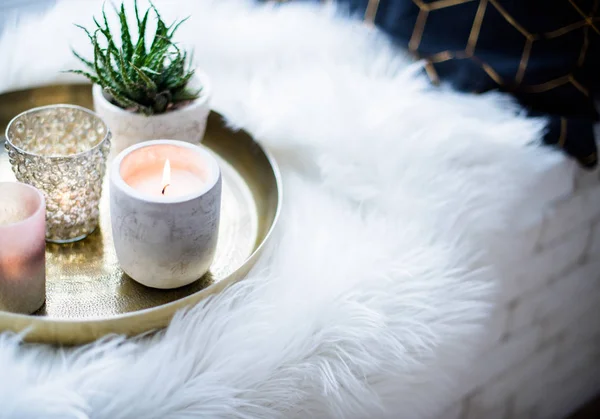 Άνετο πραγματικό σπίτι διακόσμηση, καίγοντας κεριά σε χρυσό δίσκο με μαξιλάρι σε λευκή ψεύτικη γούνα στο περβάζι — Φωτογραφία Αρχείου