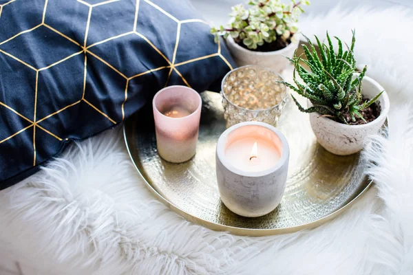 Confortable décoration de maison, bougies allumées sur plateau doré avec oreiller sur fausse fourrure blanche sur le rebord de la fenêtre — Photo