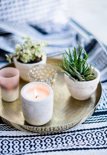 Decoração de interiores apartamento real, velas aromáticas e plantas na bandeja vintage com travesseiros e cobertor no peitoril da janela branca — Fotografia de Stock