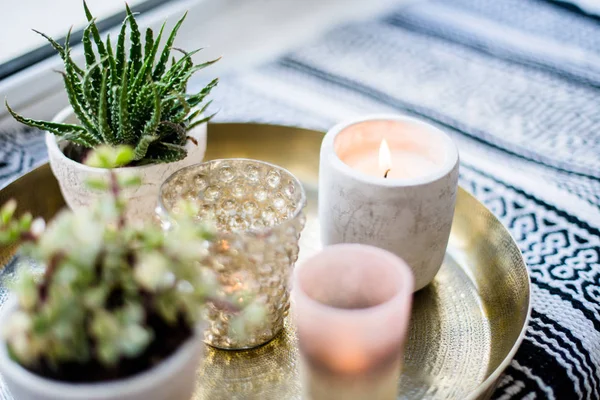 Decoração de interiores apartamento real, velas aromáticas e plantas na bandeja vintage com travesseiros e cobertor no peitoril da janela branca — Fotografia de Stock