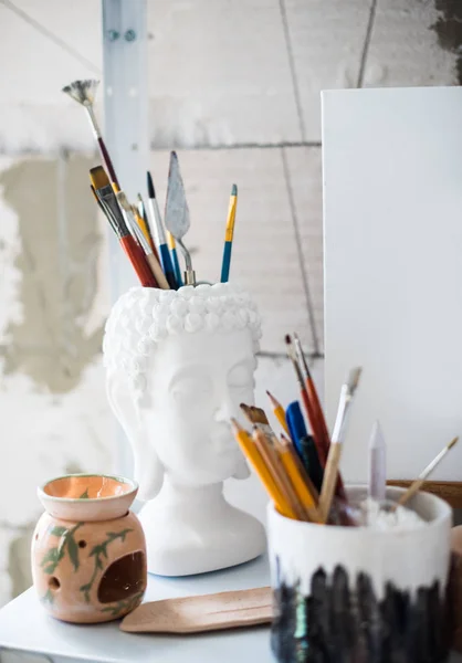 Lápis e pincéis na prateleira em estúdio artístico — Fotografia de Stock