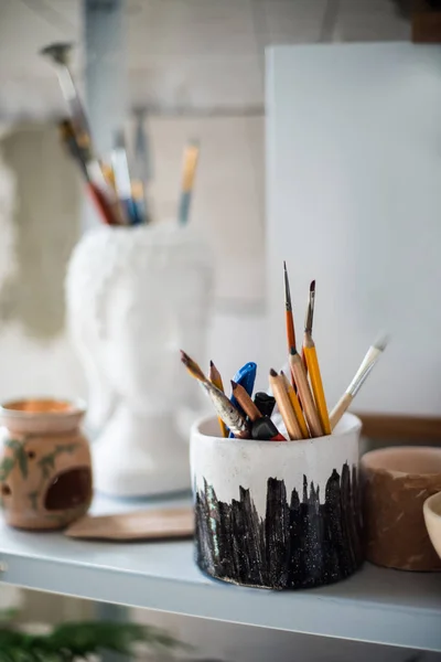 Ołówki i szczotki na półce w pracowni artystycznej — Zdjęcie stockowe