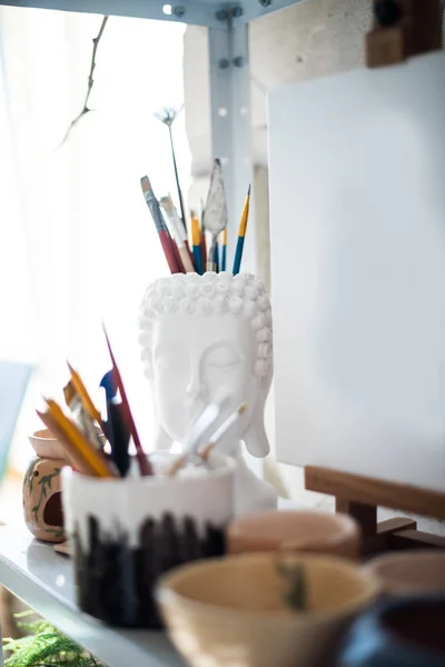 Crayons et pinceaux sur étagère dans un atelier artistique — Photo