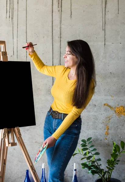 Young lady painter artist with isolated canvas artwork mock-up on easel — 스톡 사진
