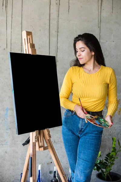 İzole edilmiş tuval resimleriyle genç bayan ressam resim sehpasında maket yapıyor. — Stok fotoğraf