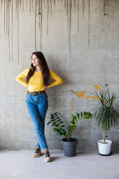 Jongedame in gele blouse en blauwe jeans — Stockfoto