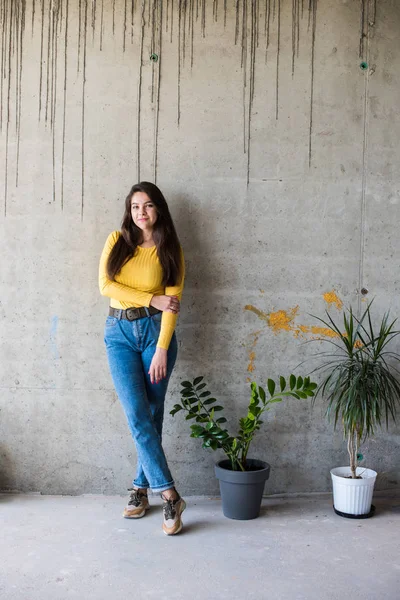 Jongedame in gele blouse en blauwe jeans — Stockfoto