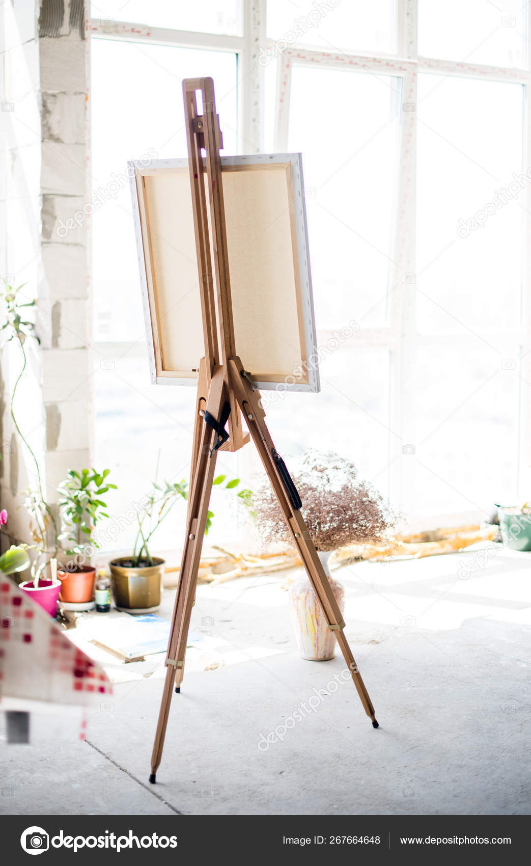 Easel with canvas standing in empty artistic studio Stock Photo by