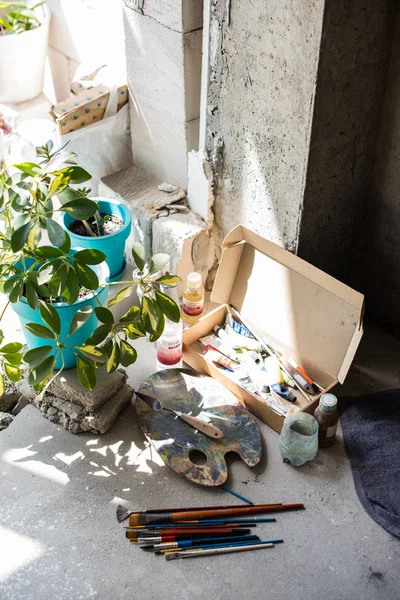 Pinceles y pinturas surtidas en el suelo del estudio de artistas — Foto de Stock