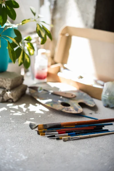 Pinceles y pinturas surtidas en el suelo del estudio de artistas —  Fotos de Stock