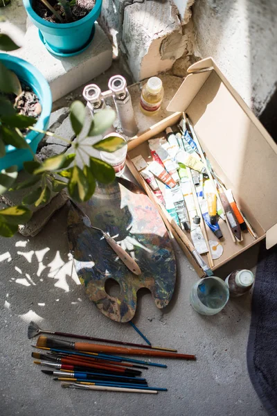 Pinceles y pinturas surtidas en el suelo del estudio de artistas —  Fotos de Stock