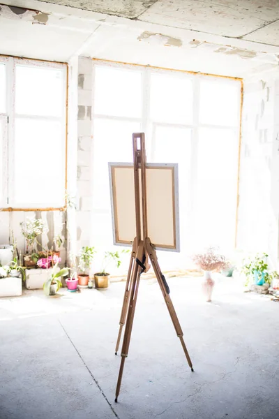 Easel com tela de pé em estúdio artístico vazio — Fotografia de Stock