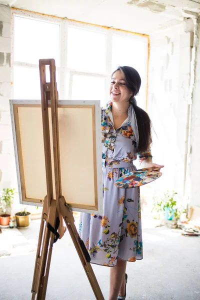 Young beautiful lady painter in dress, woman artist painting