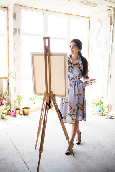 Young beautiful lady painter in dress, woman artist painting