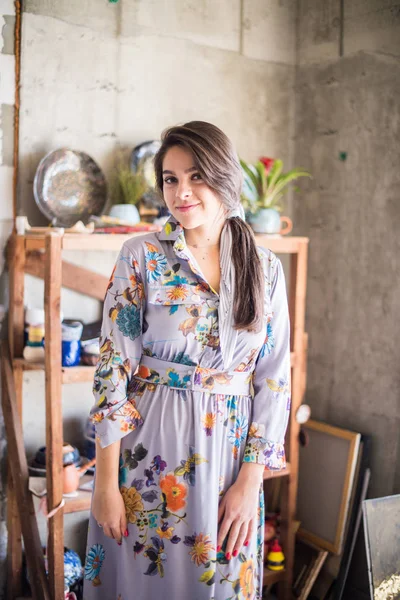 Beautiful lady artist standing in her studio, creative business owner