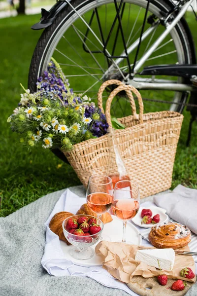 Прекрасний літній пікнік з полуницею, сиром і трояндовим вином на газоні в міському парку — стокове фото