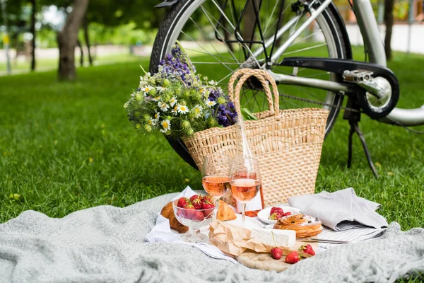 Beau pique-nique d'été avec fraises, fromage et vin rose sur la pelouse dans le parc de la ville — Photo