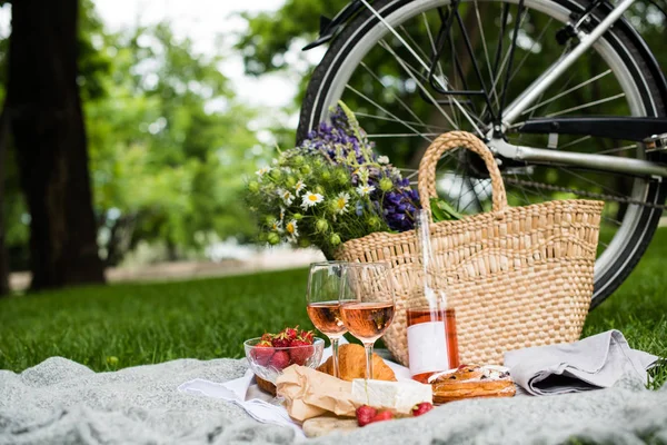 Bellissimo picnic estivo con fragole, formaggio e vino rosato sul prato nel parco cittadino — Foto Stock