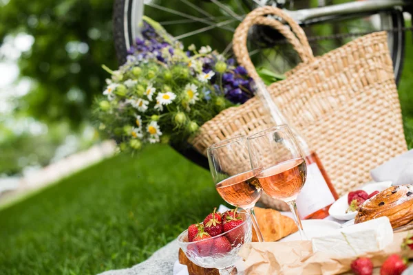 Bellissimo picnic estivo con fragole, formaggio e vino rosato sul prato nel parco cittadino — Foto Stock