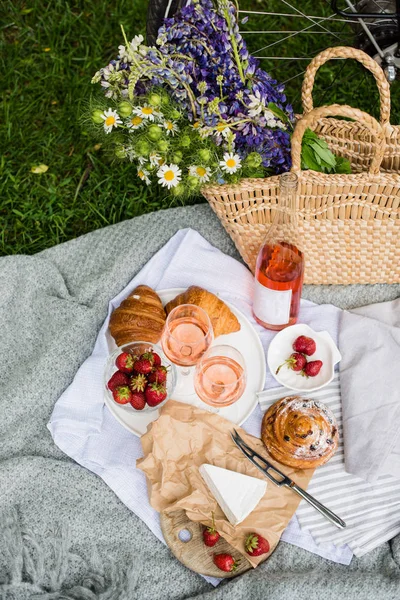 Hermoso picnic de verano con fresas, queso y vino de rosas en el césped en el parque de la ciudad —  Fotos de Stock