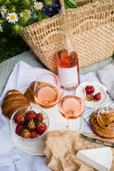 Hermoso picnic de verano con fresas, queso y vino de rosas en el césped en el parque de la ciudad —  Fotos de Stock