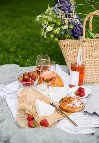 Bellissimo picnic estivo con fragole, formaggio e vino rosato sul prato nel parco cittadino — Foto Stock