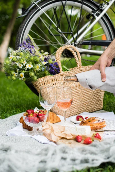 Mans mano versando vino rosato in bicchieri, picnic estivo — Foto Stock