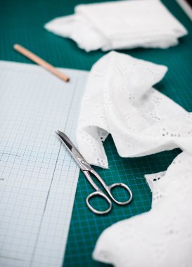 Terzi atölyesinde dikiş masasında aletler, desenler ve kumaş örnekleri