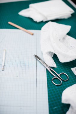 Terzi atölyesinde dikiş masasında aletler, desenler ve kumaş örnekleri