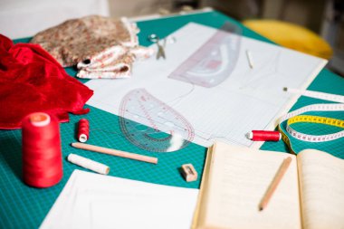 Terzi atölyesinde dikiş masasında aletler, desenler ve kumaş örnekleri