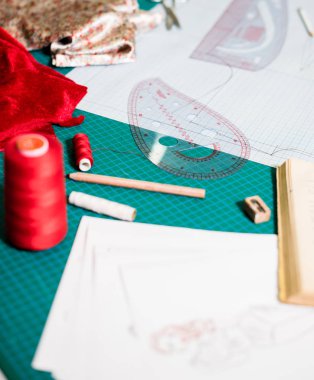 Terzi atölyesinde dikiş masasında aletler, desenler ve kumaş örnekleri