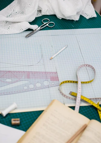 テーラーワークショップの縫製テーブル上のツール、パターン、ファブリックサンプル — ストック写真