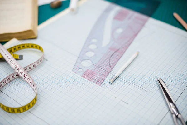 Narzędzia, wzory i próbki tkanin na stole do szycia w warsztacie krawieckim — Zdjęcie stockowe