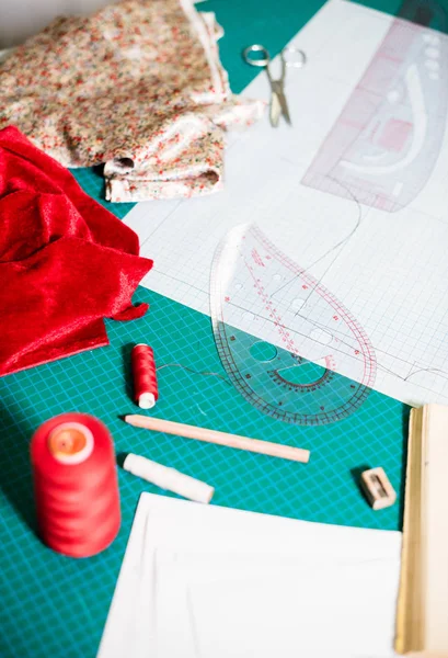 Herramientas, patrones y muestras de tela en la mesa de coser en el taller de sastrería —  Fotos de Stock