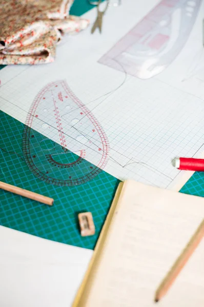 Herramientas, patrones y muestras de tela en la mesa de coser en el taller de sastrería —  Fotos de Stock