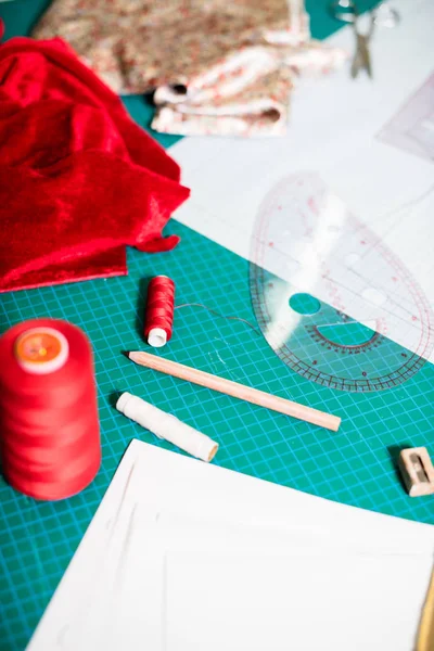 Herramientas, patrones y muestras de tela en la mesa de coser en el taller de sastrería —  Fotos de Stock