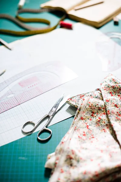 裁缝车间缝纫台上的工具、图案和织物样品 — 图库照片
