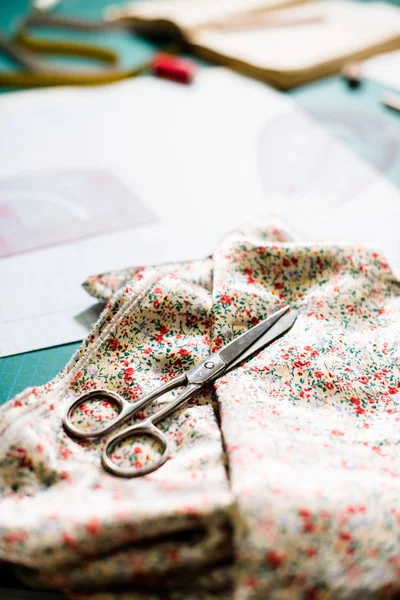 Nástroje, vzory a vzorky tkanin na Šicí stolek v krejčovské dílně — Stock fotografie