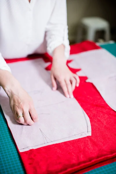 Ruce Lady Krejčí pracují ve svém studiu, nástrojích a vzorcích textilií na šicí tabulce — Stock fotografie