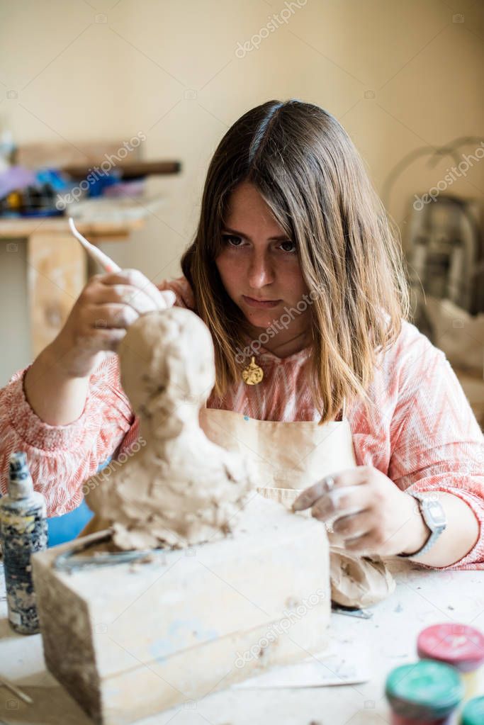 Lady sculptor working in her studio, ceramis artists hands
