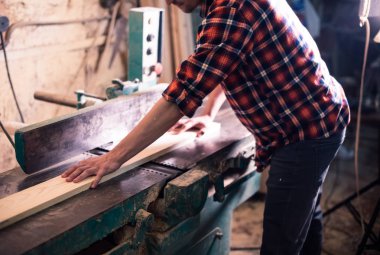 Genç yakışıklı doğrama onun marangozluk atölyesinde ahşap ile çalışan