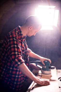 Genç yakışıklı doğrama onun marangozluk atölyesinde ahşap ile çalışan