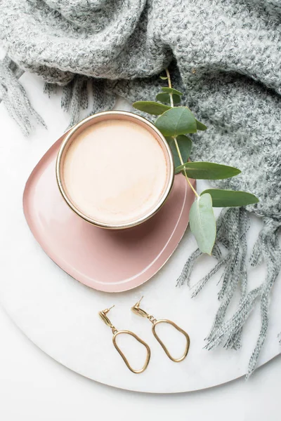 Gouden oorbellen en koffie op sieraden plaat met beige zijde doek — Stockfoto