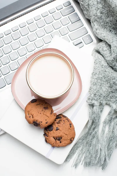 Beautiful enameled pink cup of coffee with blanket and laptop