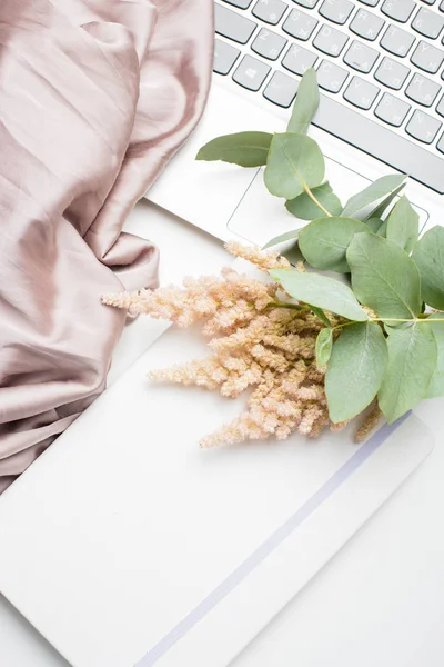 Small bouquet of flowers with blanket and laptop — Stock Photo, Image